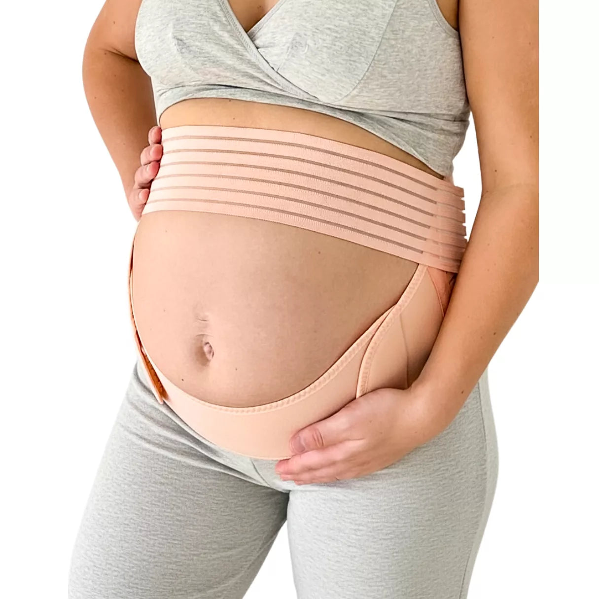 An expecting mom wearing a beige maternity support belt, front view, on a white background.